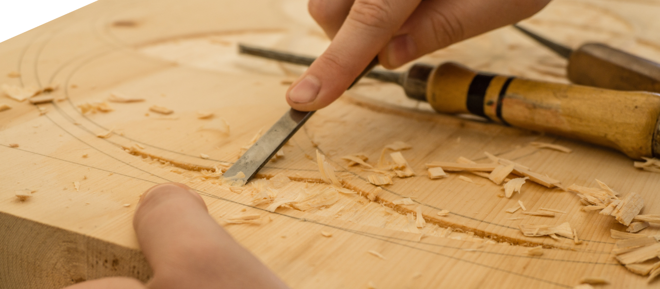Main qui tient un outil pour graver une planche de bois